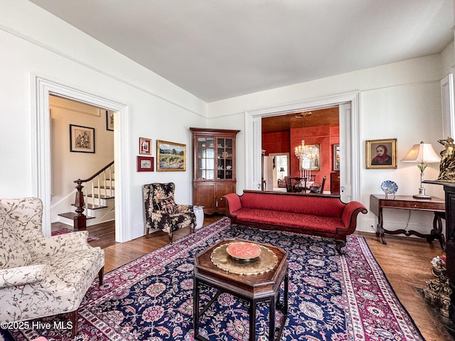 living room with wood finished floors, baseboards, and stairway