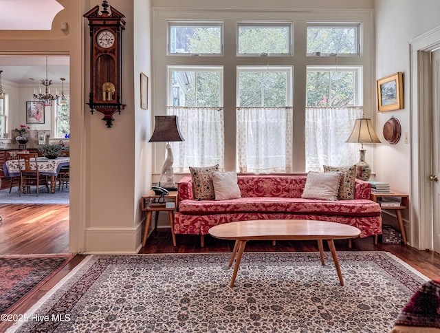 living area featuring a notable chandelier, a healthy amount of sunlight, and wood finished floors