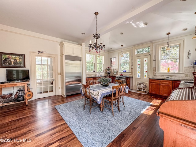 dining space featuring vaulted ceiling, a notable chandelier, and dark wood-style flooring