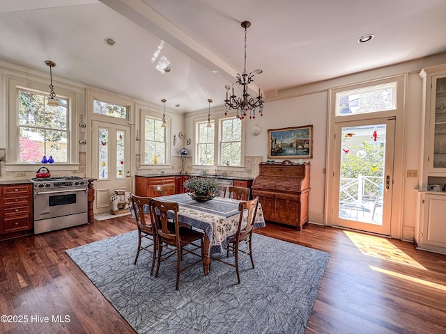dining space with dark wood-type flooring, lofted ceiling, recessed lighting, and an inviting chandelier