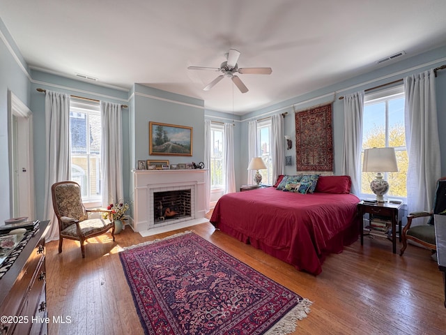 bedroom featuring hardwood / wood-style flooring, multiple windows, and visible vents