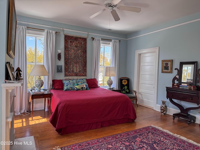 bedroom with a ceiling fan, wood finished floors, multiple windows, and visible vents