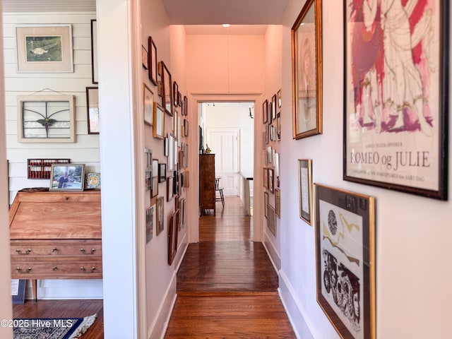hallway with dark wood finished floors and baseboards