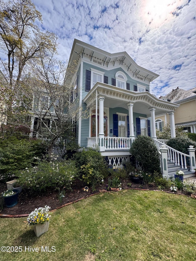 italianate-style house featuring a porch and a front yard