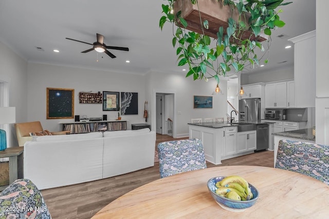dining space with ceiling fan, light wood-style floors, recessed lighting, visible vents, and ornamental molding