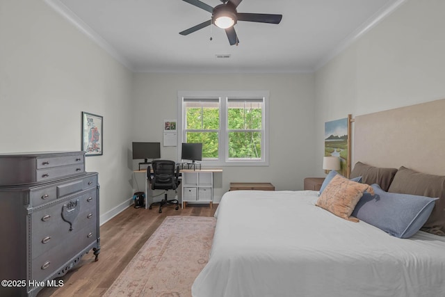 bedroom with a ceiling fan, visible vents, crown molding, wood finished floors, and baseboards