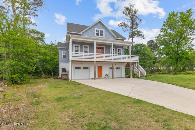 coastal inspired home with covered porch, stairway, a front lawn, concrete driveway, and an attached garage