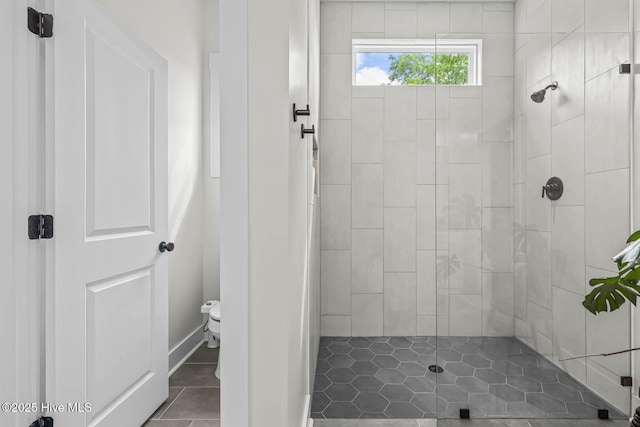 full bathroom featuring toilet, tile patterned floors, and tiled shower