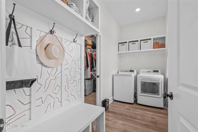washroom with laundry area, recessed lighting, wood finished floors, and washer and dryer
