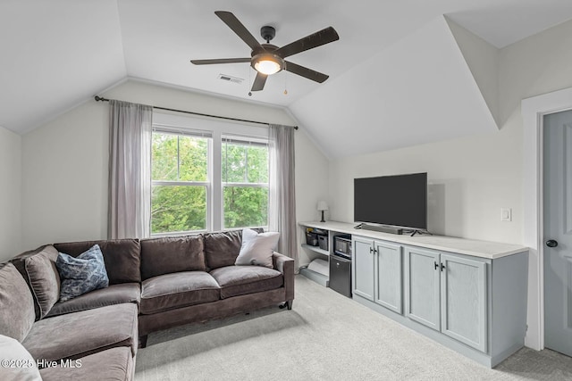 living room with visible vents, ceiling fan, vaulted ceiling, and light carpet