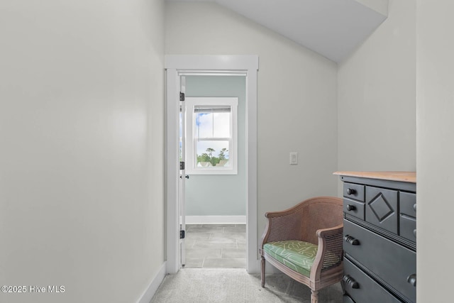 living area with baseboards, carpet, and lofted ceiling