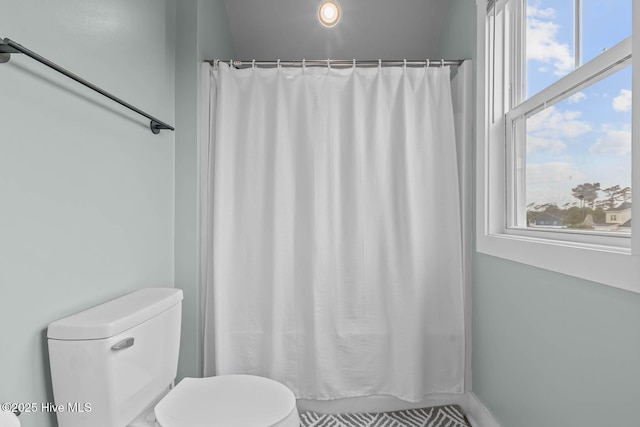 bathroom featuring toilet and a shower with curtain