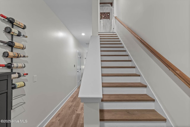staircase with recessed lighting, baseboards, and wood finished floors