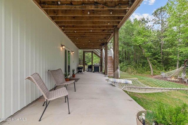 view of patio featuring stairs and a grill