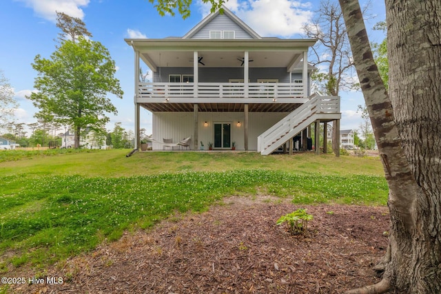 rear view of house with a ceiling fan, stairway, a yard, and a deck