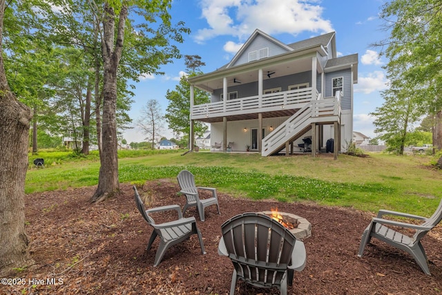 rear view of house featuring stairs, an outdoor fire pit, ceiling fan, a deck, and a yard