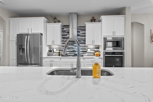 104 Plantation Dr, Southern Pines, NC 28387 - kitchen featuring a sink, white cabinetry, arched walkways, and stainless steel appliances