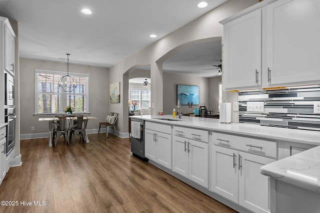 104 Plantation Dr, Southern Pines, NC 28387 - kitchen featuring arched walkways, a sink, appliances with stainless steel finishes, ceiling fan with notable chandelier, and dark wood-type flooring