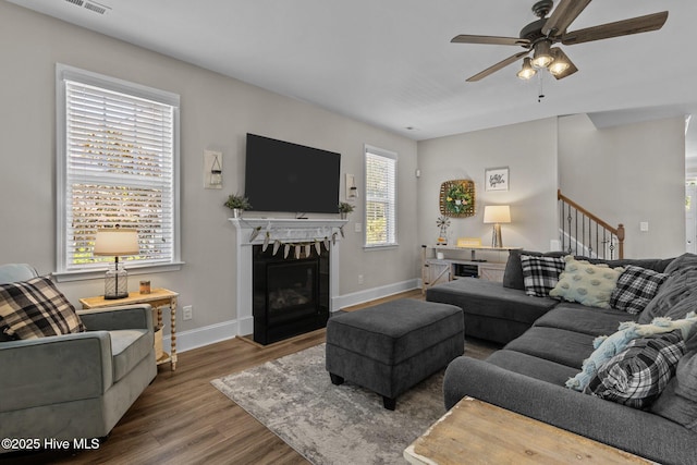 104 Plantation Dr, Southern Pines, NC 28387 - living area featuring a fireplace with flush hearth, a ceiling fan, stairway, wood finished floors, and baseboards