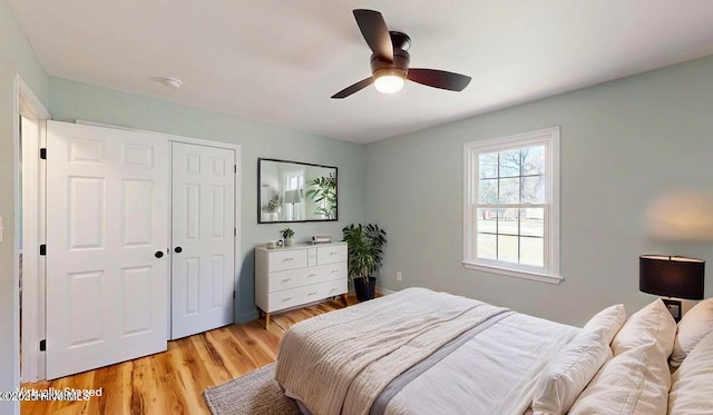 bedroom with a ceiling fan, a closet, and light wood-style flooring