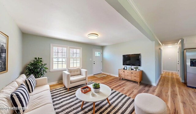 living area with light wood-style floors and baseboards