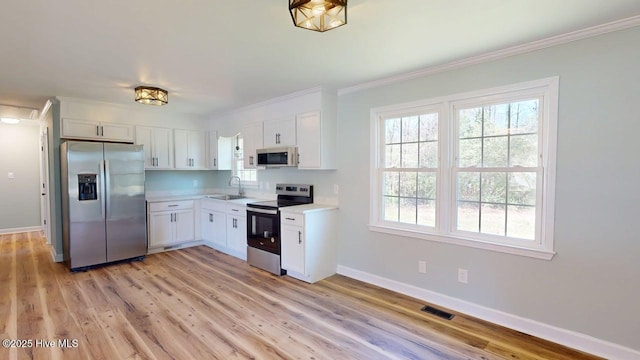 kitchen featuring a sink, light countertops, white cabinets, baseboards, and appliances with stainless steel finishes
