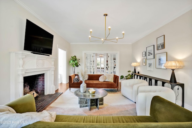 living room featuring a fireplace with flush hearth, crown molding, wood finished floors, and an inviting chandelier