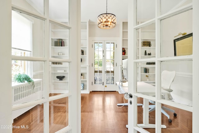 interior space with a notable chandelier and wood finished floors