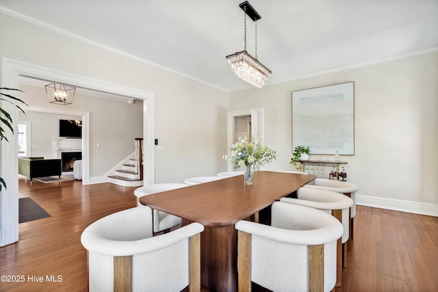 dining room featuring crown molding, wood-type flooring, and baseboards
