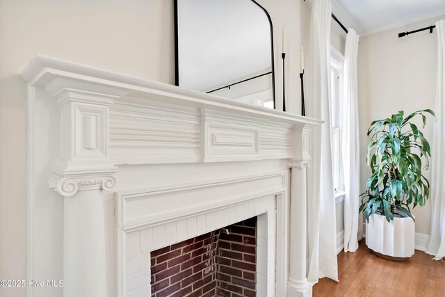 dining space with a fireplace, dark wood-type flooring, baseboards, and crown molding