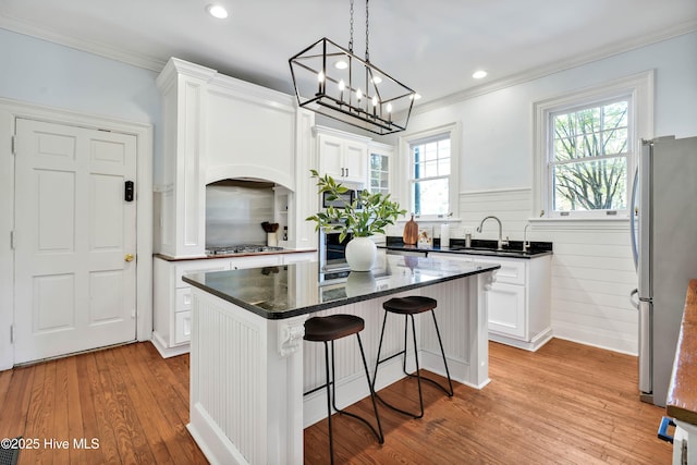kitchen featuring stainless steel appliances, light wood-style flooring, white cabinets, and a sink