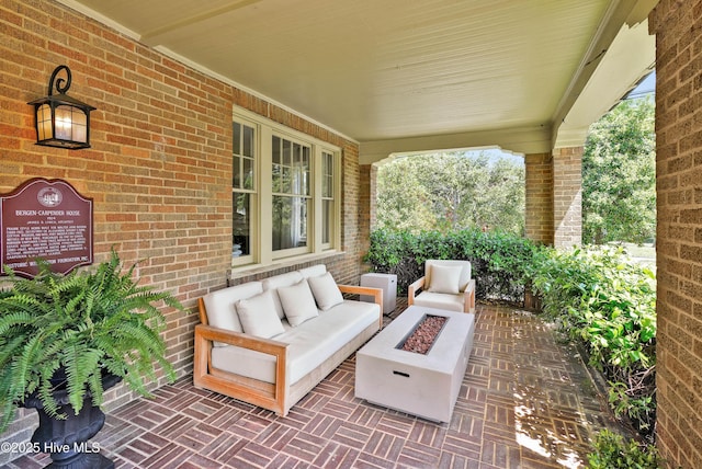 view of patio with an outdoor living space with a fire pit