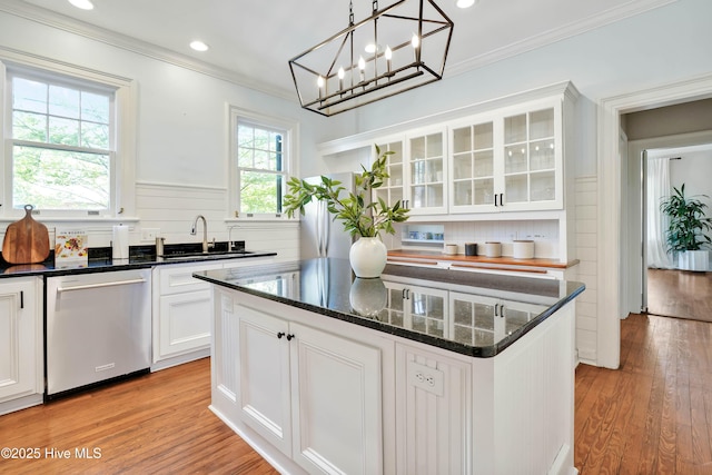 kitchen with ornamental molding, white cabinets, dishwasher, a sink, and light wood finished floors