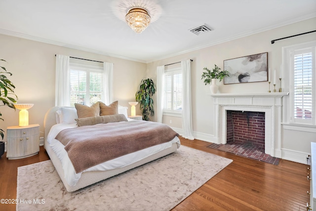 bedroom with visible vents, multiple windows, crown molding, and wood finished floors