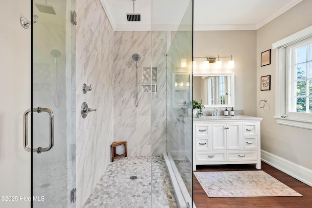 bathroom with crown molding, a shower stall, vanity, visible vents, and baseboards