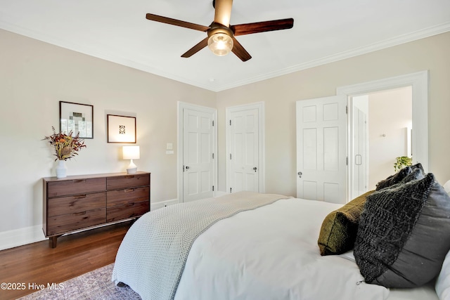 bedroom featuring dark wood-type flooring, baseboards, ornamental molding, and a ceiling fan