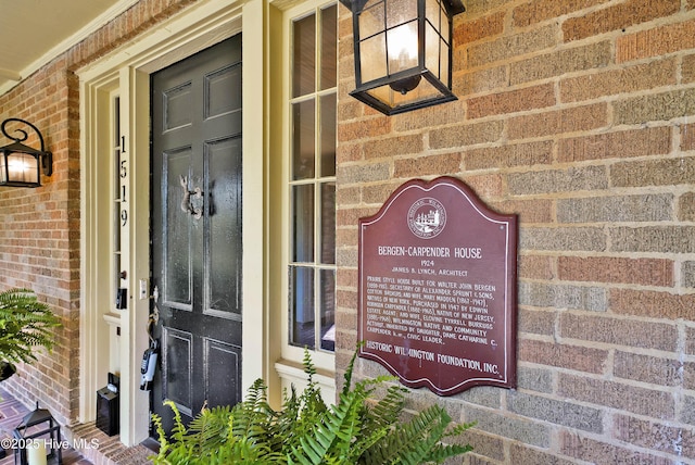 view of exterior entry featuring brick siding