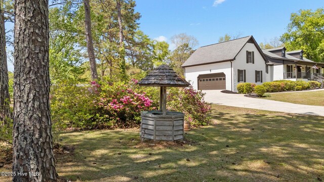 301 Pine Crest Rd, Trent Woods, NC 28562 - view of side of property with concrete driveway, a garage, stucco siding, and a yard