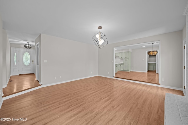 301 Pine Crest Rd, Trent Woods, NC 28562 - unfurnished living room featuring a chandelier, light wood-style floors, and baseboards