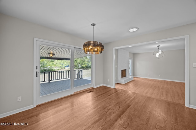 301 Pine Crest Rd, Trent Woods, NC 28562 - unfurnished living room featuring wood finished floors, a chandelier, baseboards, and a fireplace