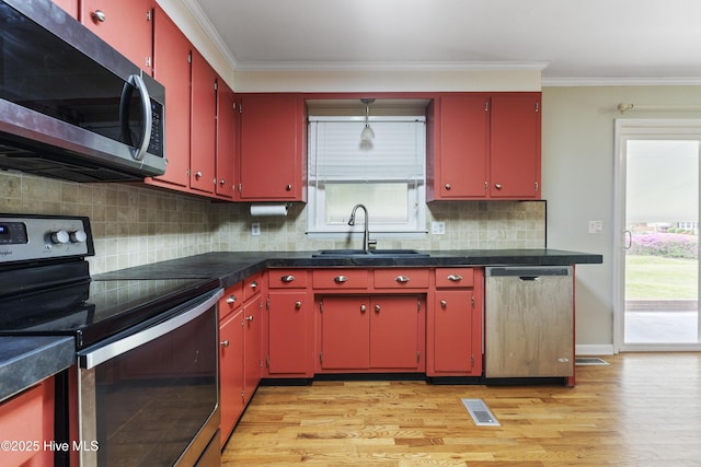117 Brookfield Dr, Wilmington, NC 28405 - kitchen featuring red cabinetry, stainless steel appliances, a sink, light wood-type flooring, and crown molding