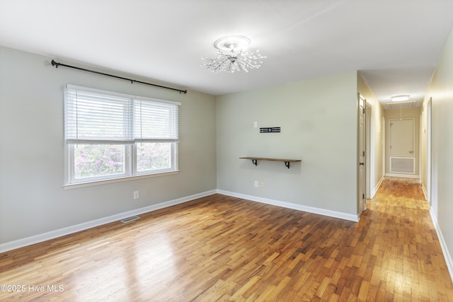 117 Brookfield Dr, Wilmington, NC 28405 - unfurnished room featuring attic access, wood finished floors, baseboards, and a chandelier
