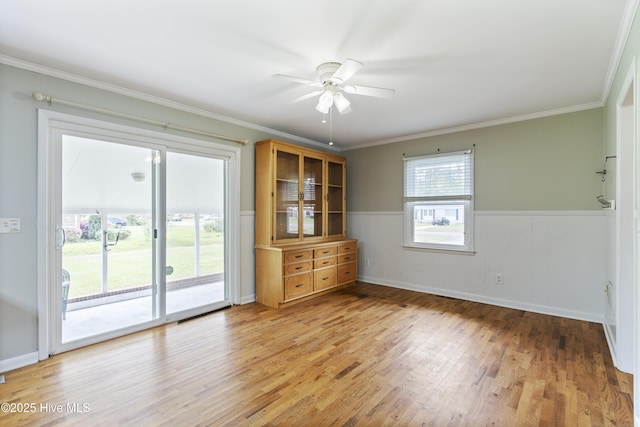 117 Brookfield Dr, Wilmington, NC 28405 - spare room featuring light wood-style floors, a wainscoted wall, ceiling fan, and crown molding
