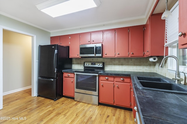 117 Brookfield Dr, Wilmington, NC 28405 - kitchen with stainless steel appliances, a sink, red cabinetry, light wood-style flooring, and ornamental molding