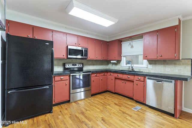 117 Brookfield Dr, Wilmington, NC 28405 - kitchen with stainless steel appliances, a sink, red cabinetry, and ornamental molding