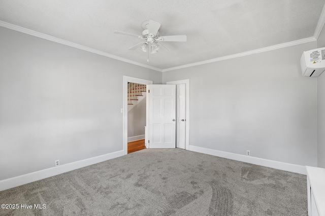 empty room featuring crown molding, a ceiling fan, carpet floors, an AC wall unit, and baseboards