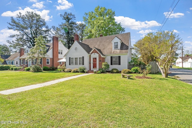 new england style home with a front yard and fence