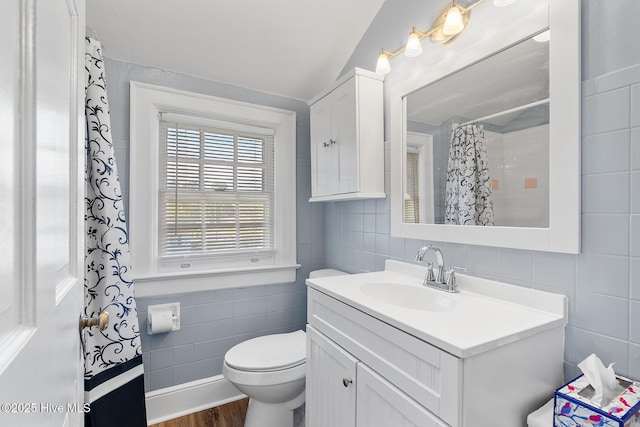 full bath with tasteful backsplash, vanity, toilet, tile walls, and wood finished floors