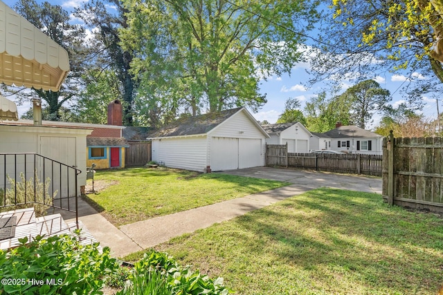 view of yard with a fenced backyard, an outdoor structure, and a garage
