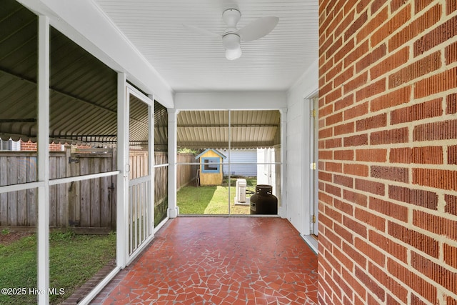 unfurnished sunroom featuring a ceiling fan